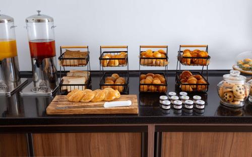 a counter with a bunch of pastries and other foods at DoubleTree by Hilton Shymkent in Shymkent