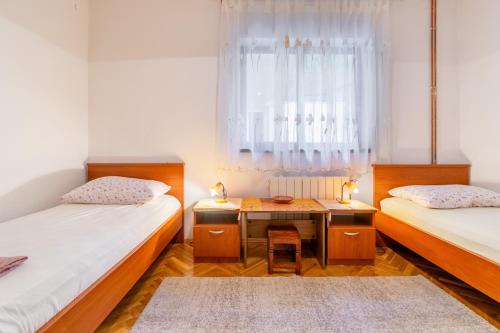 クラヴィツァにあるApartments with parking space Krvavica, Makarska - 6749のデスク、窓が備わるドミトリールームのベッド2台分です。