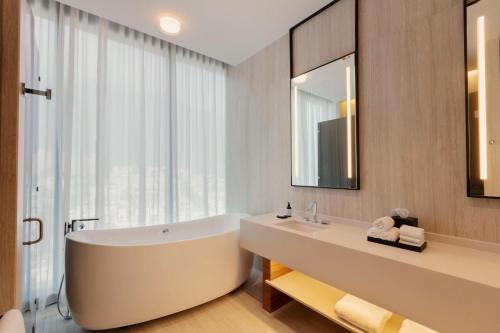 La salle de bains est pourvue d'une baignoire et d'une grande fenêtre. dans l'établissement Hilton Monterrey, à Monterrey