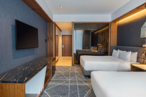 a hotel room with two beds and a television at Hilton Monterrey Valle in Monterrey