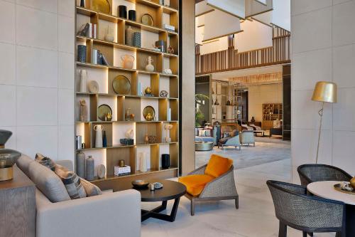 a living room with a couch and a shelf of plates at Conrad Rabat Arzana in Rabat