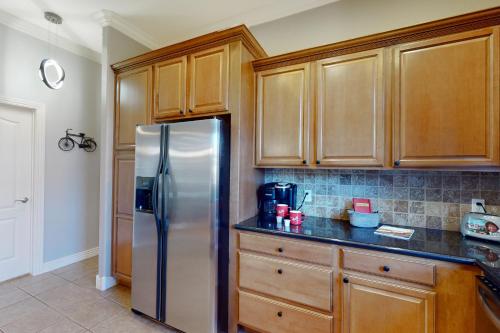 a kitchen with wooden cabinets and a stainless steel refrigerator at Windsor Retreat in Bentonville