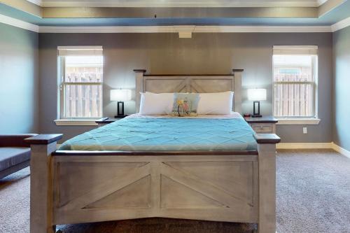 a bedroom with a large wooden bed with two windows at Windsor Retreat in Bentonville