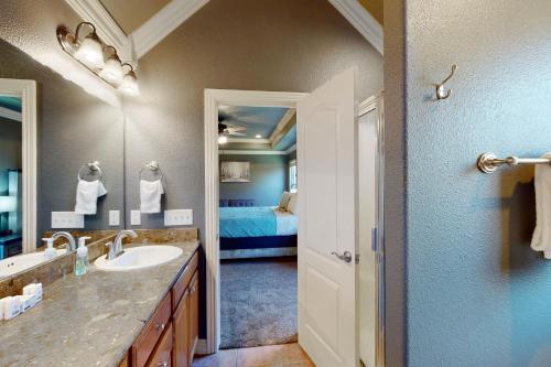 a bathroom with a sink and a bedroom with a bed at Windsor Retreat in Bentonville
