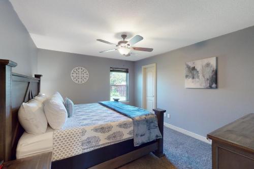 a bedroom with a bed and a ceiling fan at Windsor Retreat in Bentonville