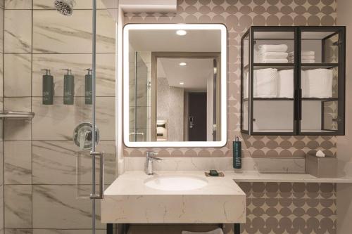 a bathroom with a sink and a mirror at DoubleTree by Hilton New York Midtown Fifth Ave in New York