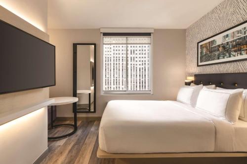 a hotel room with a bed and a flat screen tv at DoubleTree by Hilton New York Midtown Fifth Ave in New York