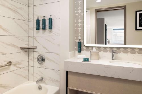 a bathroom with a sink and a mirror at DoubleTree by Hilton New York Midtown Fifth Ave in New York