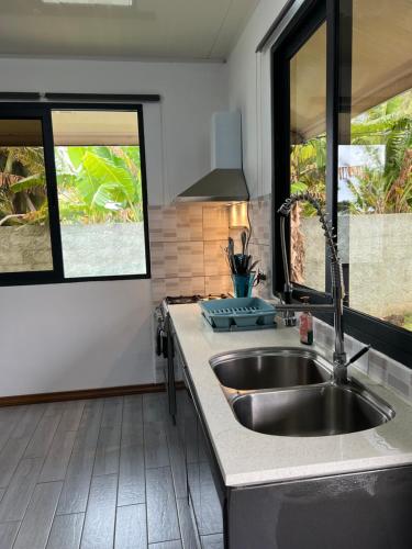 uma cozinha com um lavatório e duas janelas em Villa Toa Pearl Bora Bora em Bora Bora