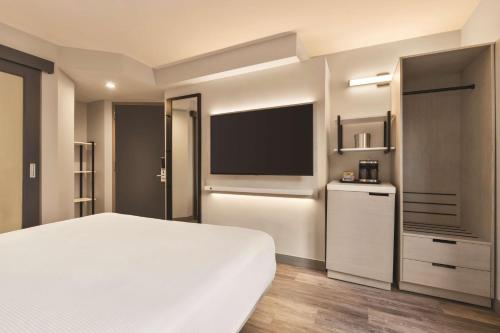 a bedroom with a white bed and a flat screen tv at DoubleTree by Hilton New York Midtown Fifth Ave in New York