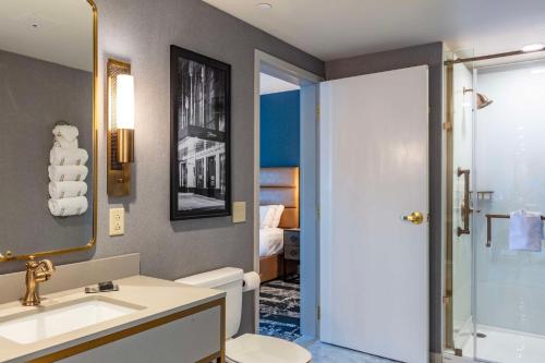 a bathroom with a sink and a toilet and a shower at The Yorktowne Hotel, Tapestry Collection by Hilton in York