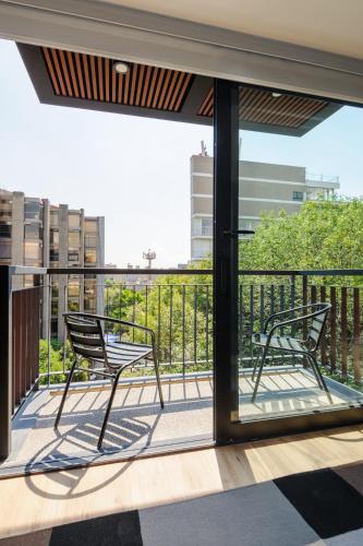 two chairs sitting on the balcony of a building at Nuevo Leon 155 by Wynwood House in Mexico City