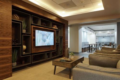 a living room with a couch and a tv at Hampton Inn Ciudad Juarez in Ciudad Juárez