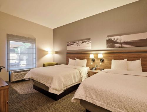 a hotel room with two beds and a window at Hampton Inn Ciudad Juarez in Ciudad Juárez