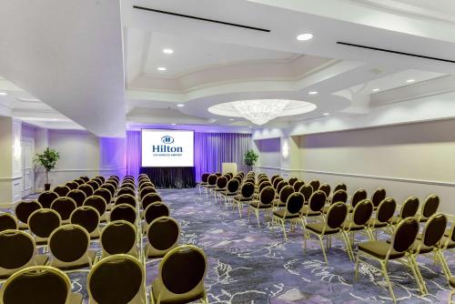 a room with rows of chairs and a stage at Hilton Los Angeles Airport in Los Angeles