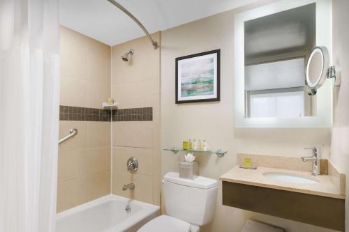 a bathroom with a toilet and a sink and a mirror at DoubleTree by Hilton Hotel New York City - Chelsea in New York