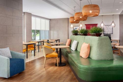 a restaurant with a green couch and tables and chairs at Home2 Suites by Hilton Lexington University / Medical Center in Lexington