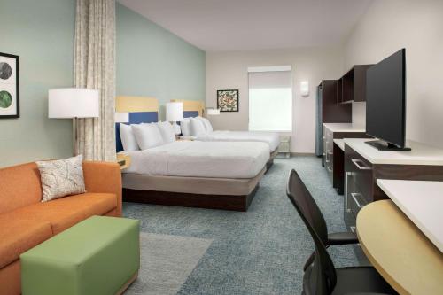 Home2 Suites by Hilton Lexington University / Medical Center في ليكسينغتون: غرفه فندقيه بسرير واريكه