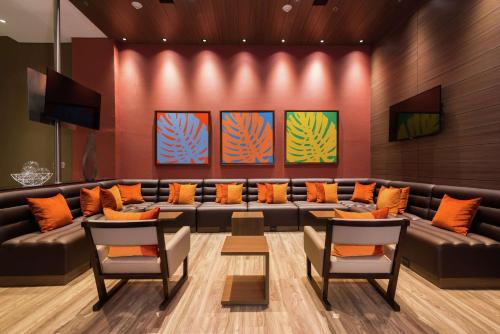 een wachtkamer met een leren bank en oranje kussens bij Hampton by Hilton Bogota Usaquen in Bogota