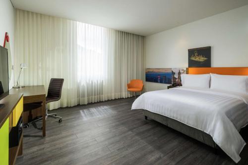 波哥大的住宿－希爾頓漢普頓波哥大烏薩昆酒店，酒店客房配有一张床、一张书桌和一台电脑