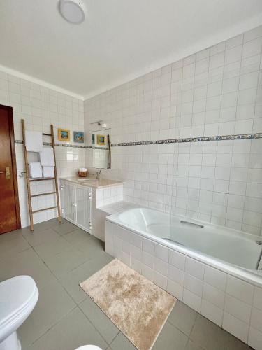 a bathroom with a tub and a sink and a toilet at A Villa Fortuna in Santo André