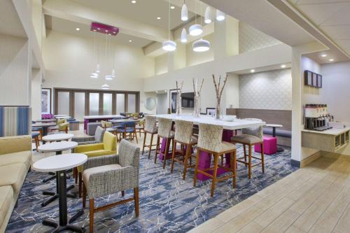 a lobby with a bar and tables and chairs at Hampton Inn & Suites Oakwood Village-Cleveland in Oakwood