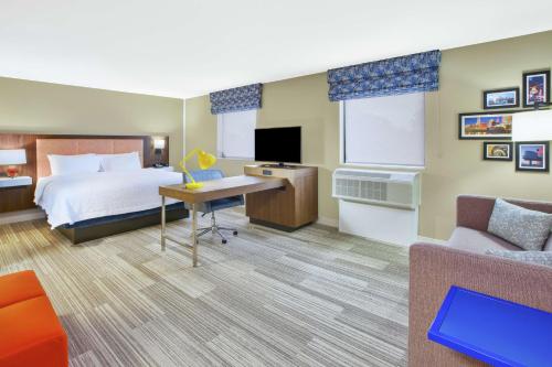 une chambre d'hôtel avec un lit et un canapé dans l'établissement Hampton Inn & Suites Oakwood Village-Cleveland, à Oakwood