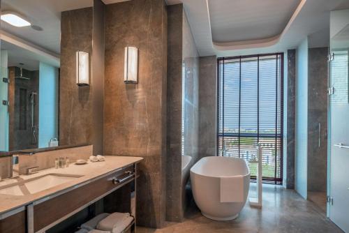a bathroom with a sink and a toilet and a mirror at Hilton Tashkent City in Tashkent