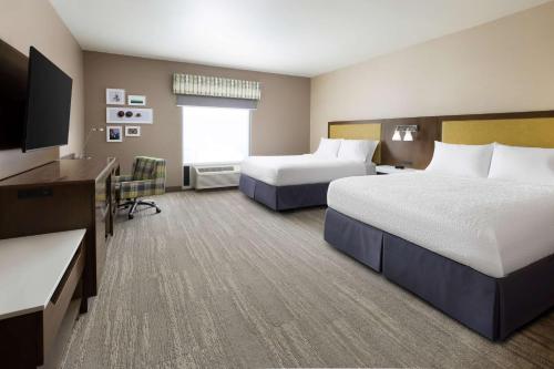 a hotel room with two beds and a flat screen tv at Hampton Inn Oakhurst-Yosemite in Oakhurst