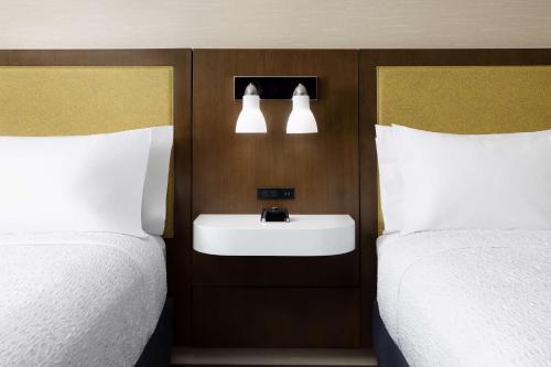 a bathroom with two beds and a sink and lights at Hampton Inn Oakhurst-Yosemite in Oakhurst
