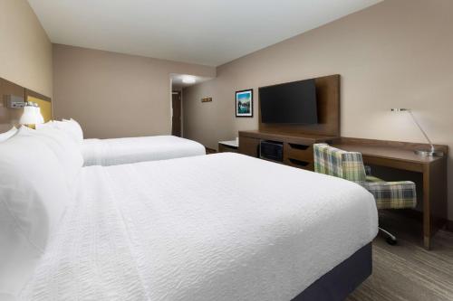 a hotel room with two beds and a flat screen tv at Hampton Inn Oakhurst-Yosemite in Oakhurst