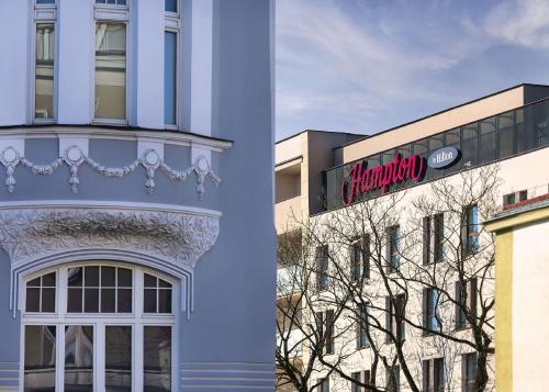 a building with a sign on the side of it at Hampton By Hilton Bialystok in Białystok