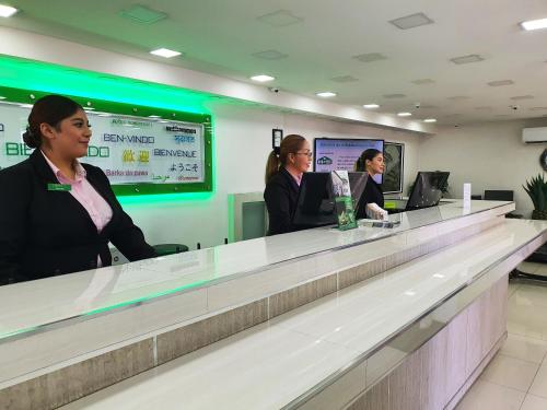 three women sitting at a counter in a waiting room at Hotel Marques de Cima in Nogales