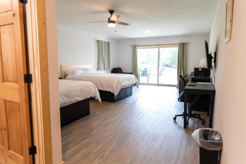 a bedroom with two beds and a desk with a computer at Bluffside Gardens in Decorah