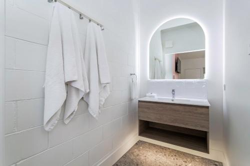 a white bathroom with a sink and a mirror at Bel Air Motel in Mackay