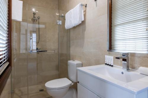 a bathroom with a toilet and a sink and a shower at Southern Cross Hotel in Sydney