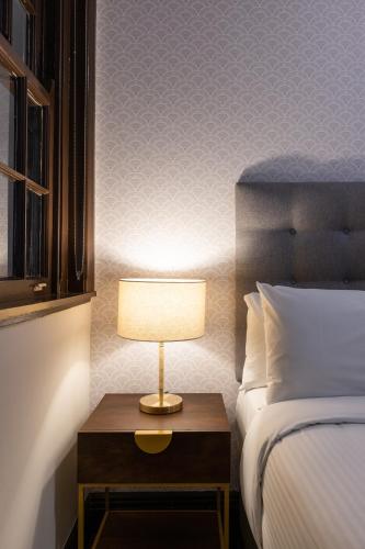 a bedroom with a bed and a table with a lamp at Southern Cross Hotel in Sydney