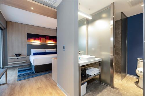 a bathroom with a bed and a sink and a toilet at Aloft Lima Miraflores in Lima