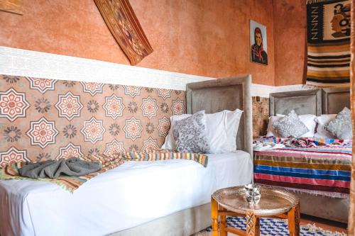 a bedroom with two beds and a table at Héritage Lalla Aicha Hotel & Spa in Marrakesh