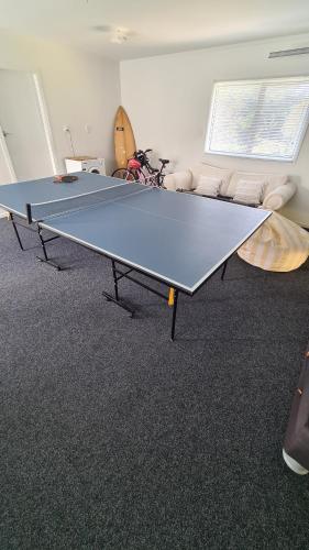 a ping pong table in the middle of a room at Matapouri bach - beautiful Northland beach in Matapouri