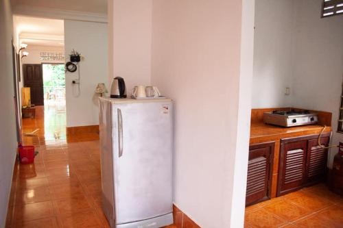 a kitchen with a white refrigerator in a room at SRL Villa in Phumi Ta Phul
