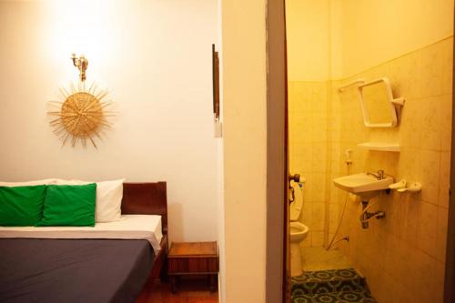 a bedroom with a bed and a bathroom with a sink at SRL Villa in Phumi Ta Phul