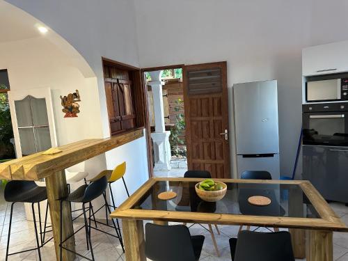 a kitchen with a glass table and some chairs at Au Moulin Paradisiaque in Port-Louis