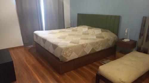 1 dormitorio con 1 cama y 1 reposapiés en Acogedor y Luminoso 2 Ambientes Centro Morón en Morón