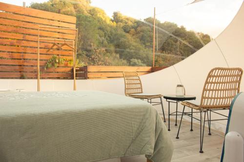 Saponara VillafrancaにあるLa Bolla di Magの椅子とベッド、窓が備わる客室です。