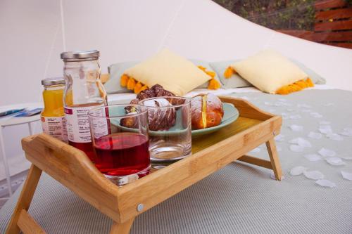 Saponara VillafrancaにあるLa Bolla di Magのベッドの上に食べ物と飲み物のトレイ