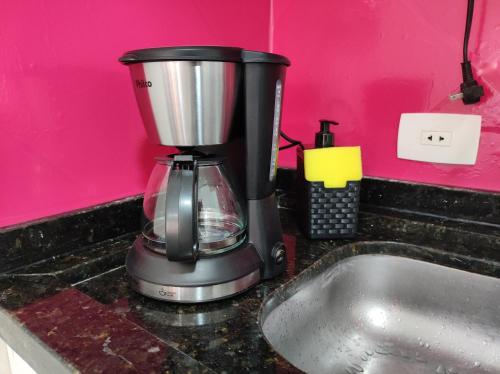 Ein Mischpult steht auf der Arbeitsfläche neben einem Spülbecken. in der Unterkunft Apartamento Curitiba Palace in Curitiba