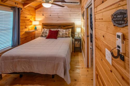 Un dormitorio con una cama en una cabaña de troncos en Cherokee Lake Rental, en Bean Station