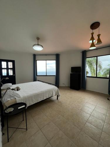 a large bedroom with a bed and two windows at Villa Colinas Del Cielo in San Cristóbal