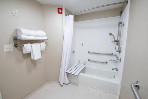 a bathroom with a tub and a shower with towels at SpringHill Suites by Marriott Winston-Salem Hanes Mall in Winston-Salem